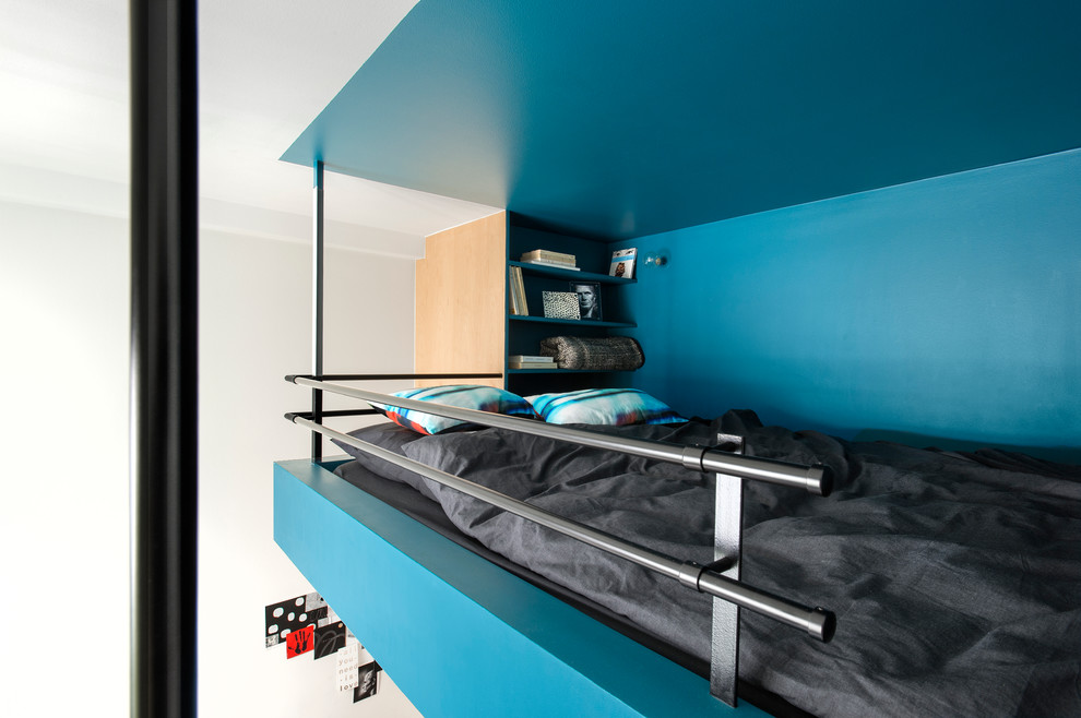 Immagine di una camera da letto stile loft contemporanea con pareti blu
