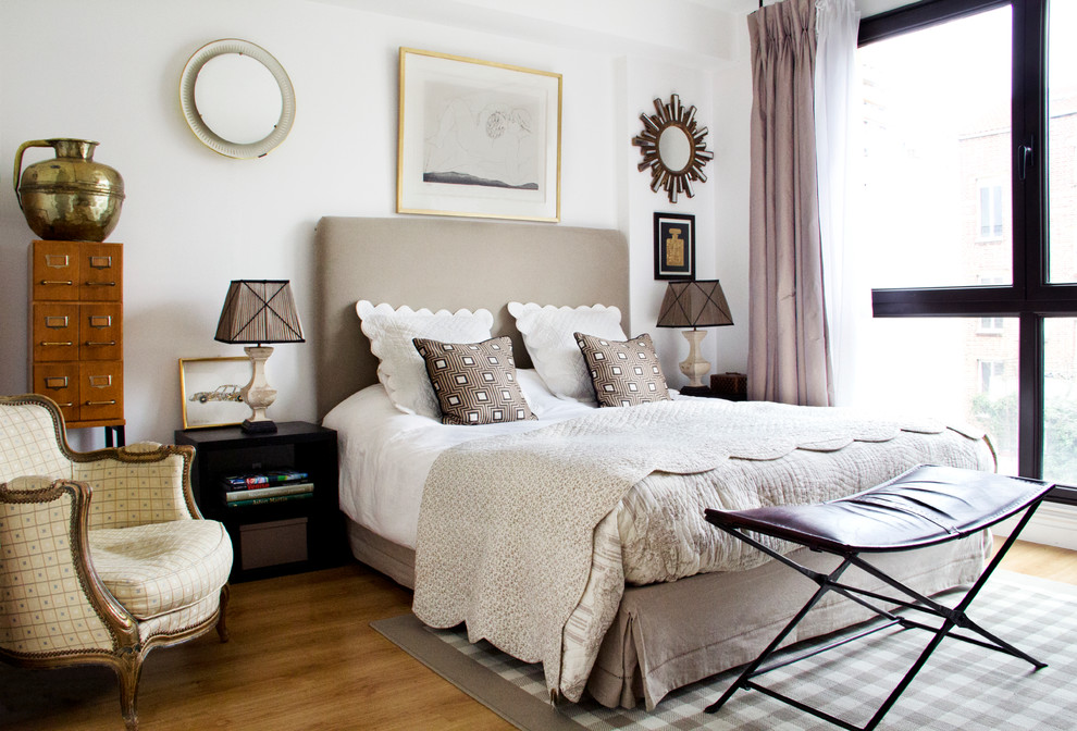 Esempio di una camera da letto eclettica con pareti bianche e parquet chiaro
