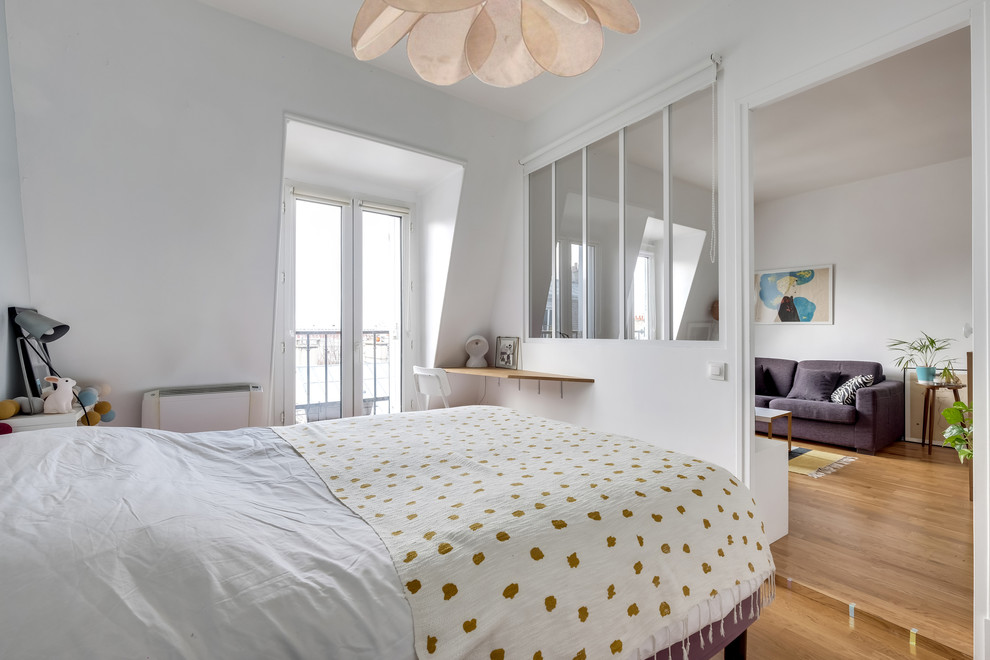 Foto de dormitorio principal nórdico de tamaño medio con paredes blancas, suelo de madera clara y suelo beige