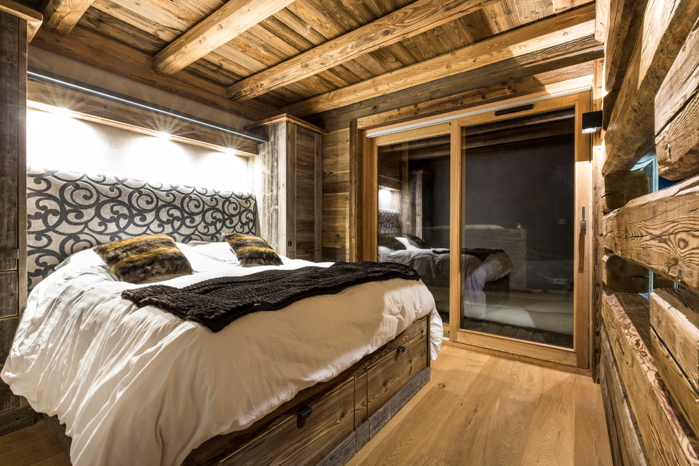 Mittelgroßes Uriges Hauptschlafzimmer ohne Kamin mit braunem Holzboden in Grenoble