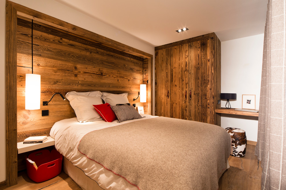 Ejemplo de dormitorio principal y blanco y madera rural de tamaño medio sin chimenea con paredes blancas y suelo de madera en tonos medios