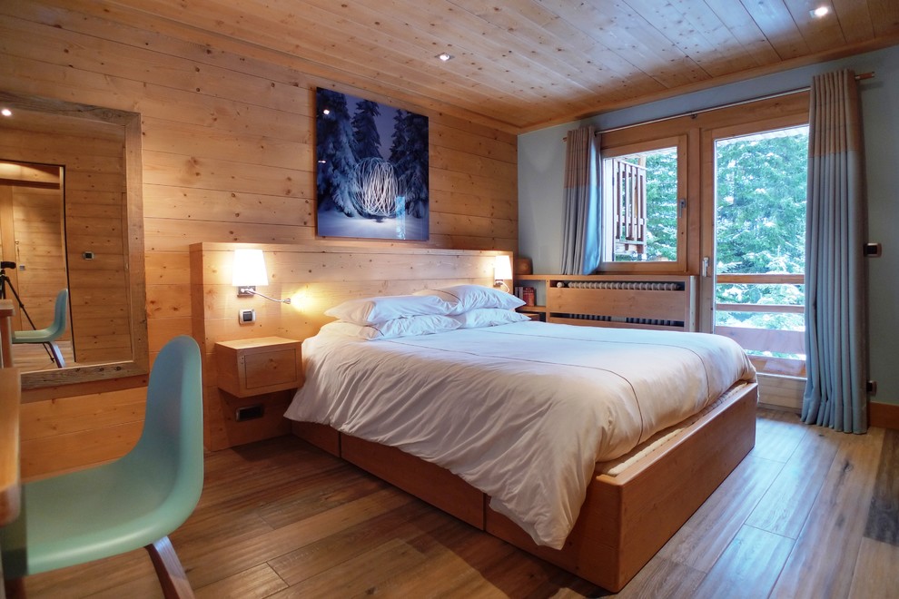 Foto de dormitorio rural con paredes beige y suelo de madera clara