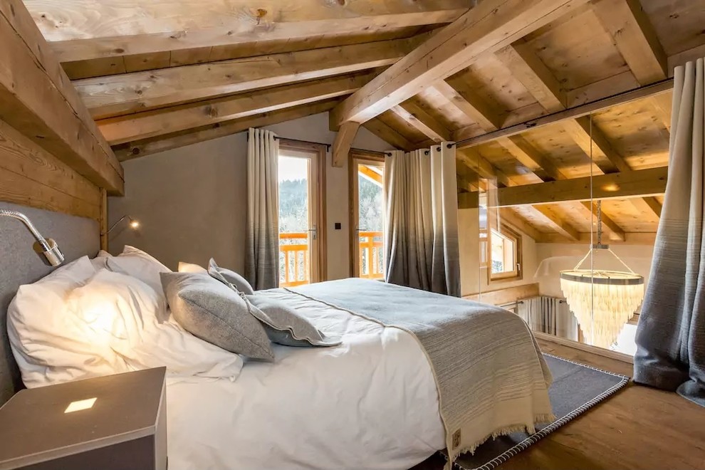 Inspiration pour une petite chambre mansardée ou avec mezzanine chalet avec un mur beige, parquet clair et aucune cheminée.