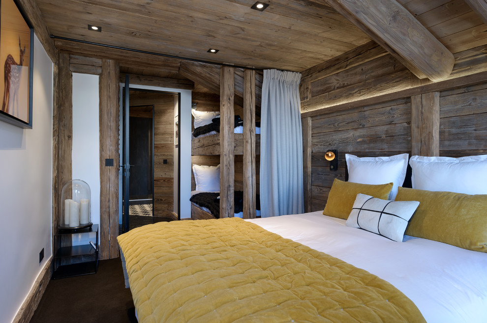Ejemplo de habitación de invitados rústica con moqueta, paredes marrones y suelo marrón
