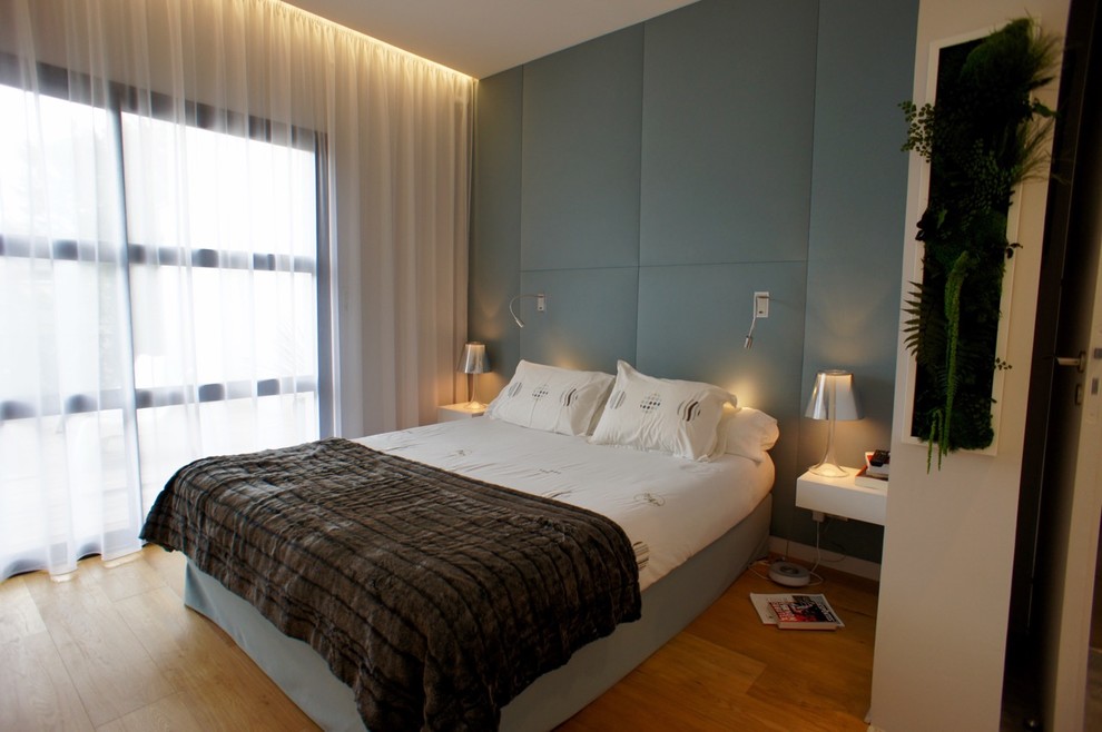 На фото: большая хозяйская спальня в современном стиле с синими стенами и полом из бамбука без камина с