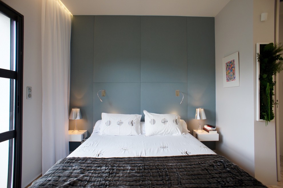 Стильный дизайн: большая хозяйская спальня в скандинавском стиле с синими стенами и полом из бамбука без камина - последний тренд