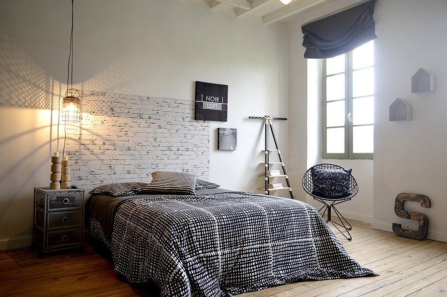 Cette photo montre une grande chambre parentale industrielle avec un mur blanc, sol en stratifié et un sol beige.