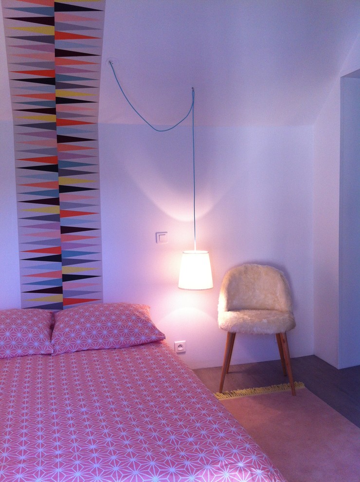Cette photo montre une chambre d'amis moderne de taille moyenne avec un mur blanc, un sol en bois brun et un sol marron.
