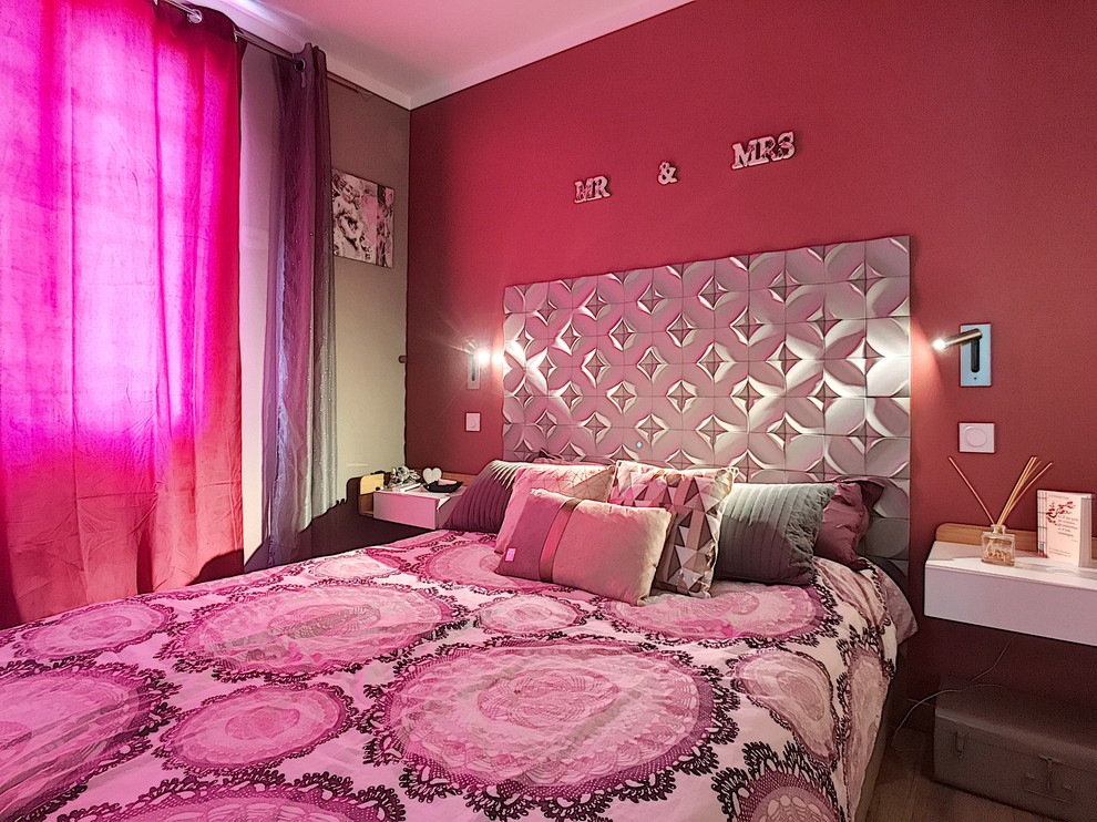 This is an example of a medium sized contemporary master bedroom in Nice with pink walls, light hardwood flooring and beige floors.