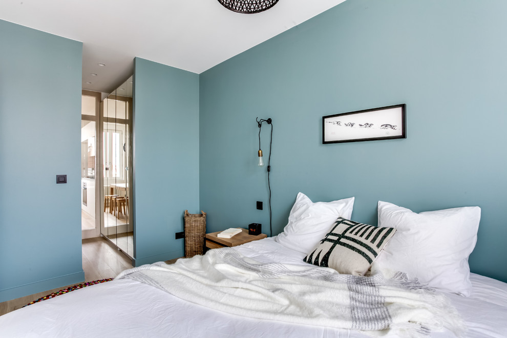 Aménagement d'une petite chambre parentale scandinave avec un mur bleu et parquet clair.