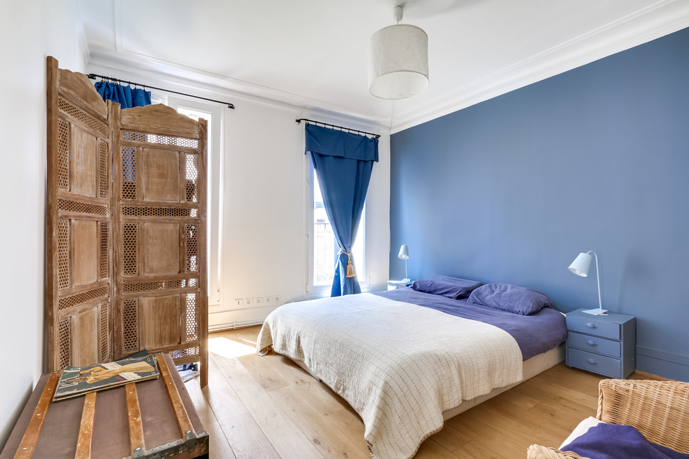 パリにある中くらいな北欧スタイルのおしゃれな主寝室 (青い壁、淡色無垢フローリング)
