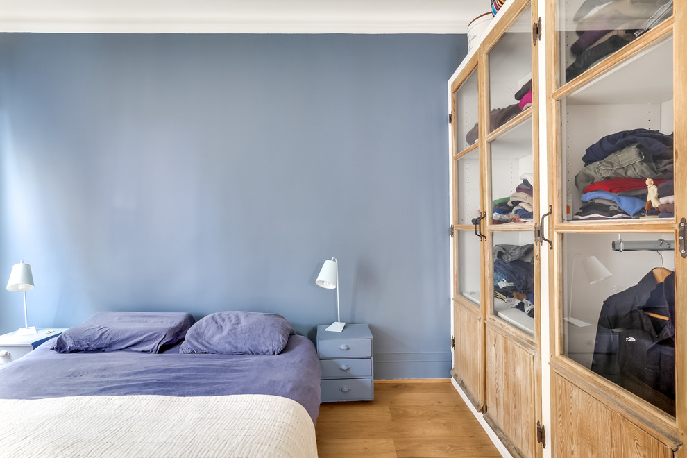 Mittelgroßes Skandinavisches Hauptschlafzimmer mit blauer Wandfarbe und hellem Holzboden in Paris