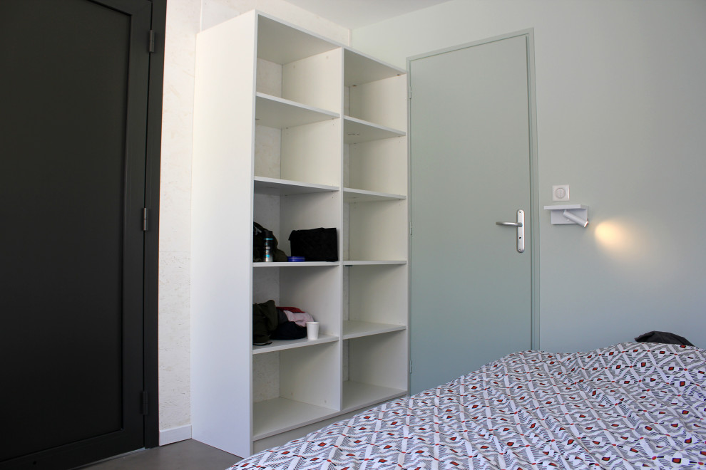 Modelo de habitación de invitados moderna pequeña con paredes azules, suelo vinílico, suelo marrón y madera