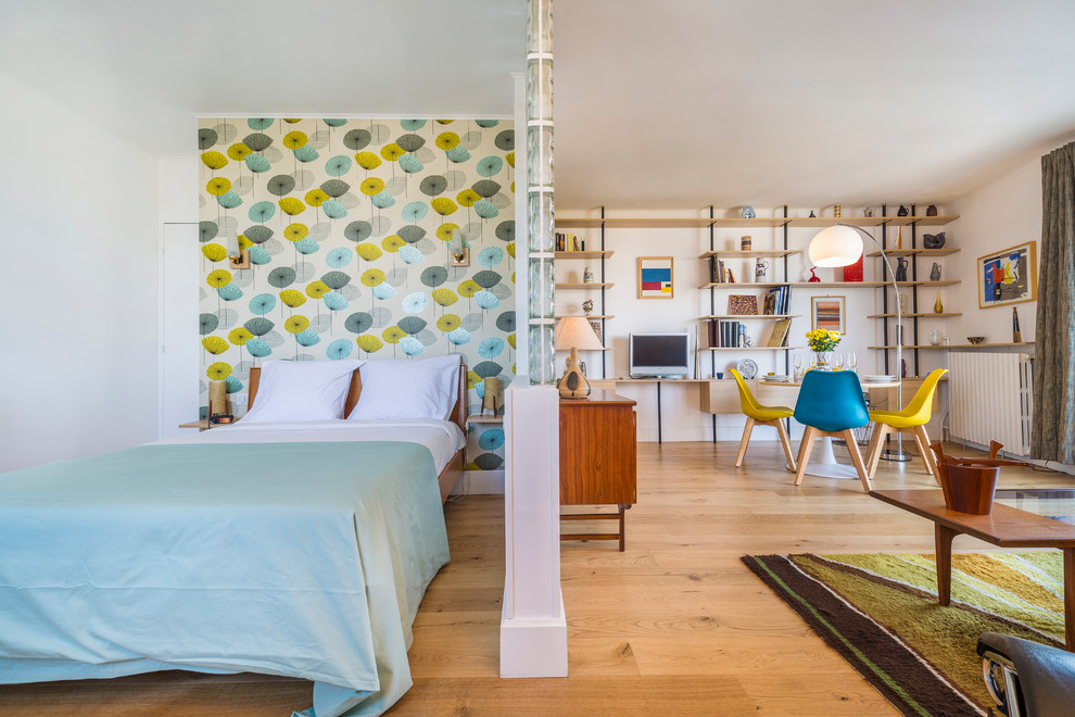 Mittelgroßes Retro Hauptschlafzimmer ohne Kamin mit bunten Wänden, hellem Holzboden und braunem Boden in Paris