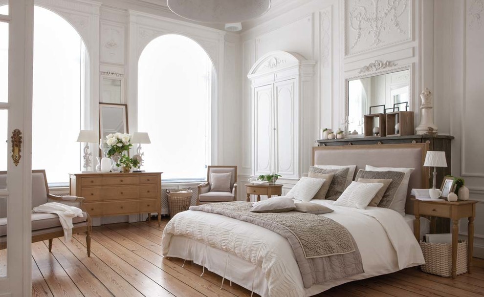 На фото: хозяйская спальня в стиле неоклассика (современная классика) с белыми стенами и светлым паркетным полом с