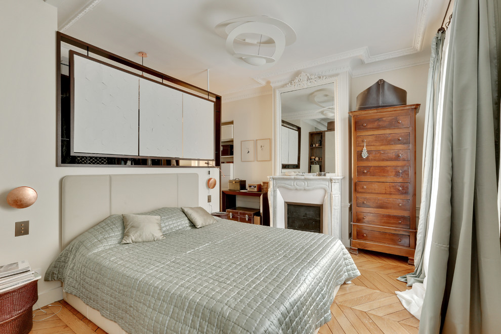 Exemple d'une chambre parentale chic de taille moyenne avec un mur blanc, parquet clair, une cheminée standard et un sol marron.