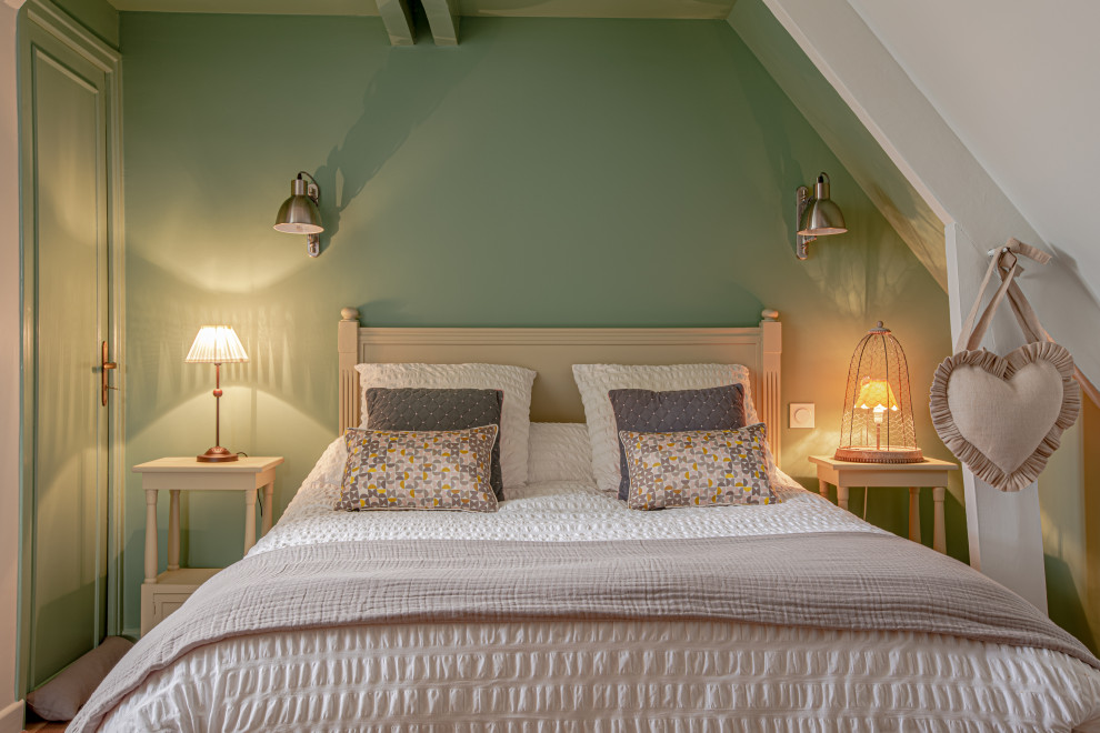 Imagen de habitación de invitados tradicional renovada de tamaño medio sin chimenea con paredes verdes, suelo laminado y suelo marrón