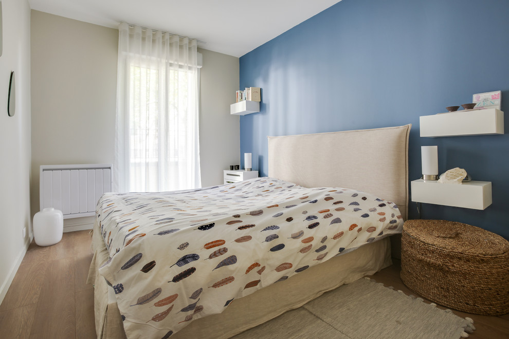 パリにある小さなコンテンポラリースタイルのおしゃれな主寝室 (青い壁、ラミネートの床、暖炉なし、茶色い床) のインテリア