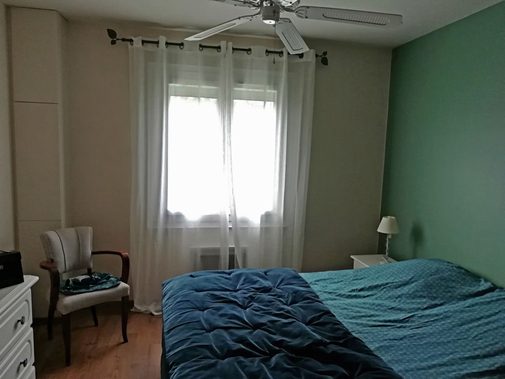 Cette photo montre une chambre parentale de taille moyenne avec un mur vert, parquet clair, aucune cheminée et un sol marron.
