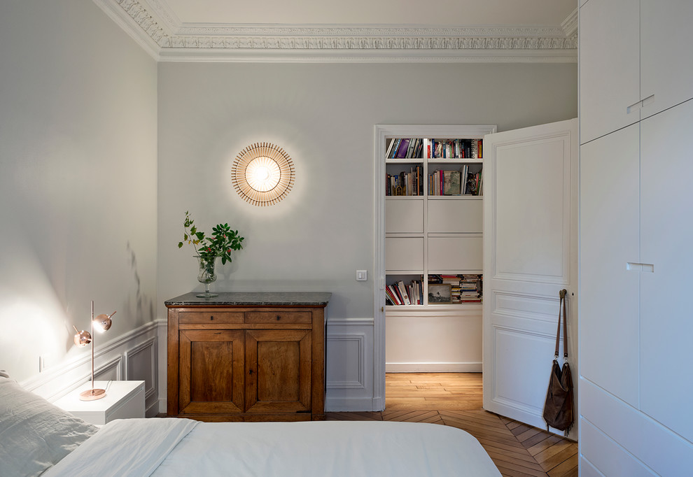 Diseño de dormitorio principal tradicional renovado de tamaño medio con paredes grises y suelo de madera en tonos medios