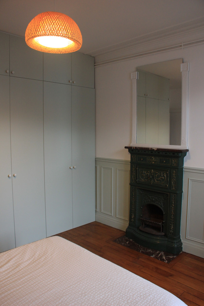 Medium sized contemporary master bedroom in Paris with blue walls and dark hardwood flooring.