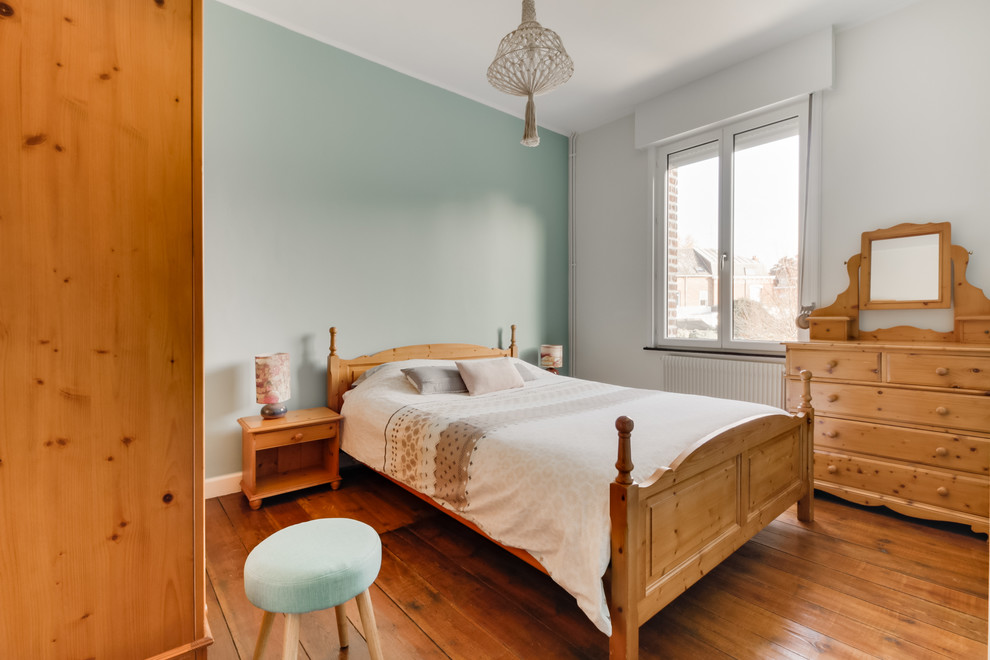 Foto de dormitorio principal nórdico de tamaño medio sin chimenea con paredes verdes y suelo de madera clara