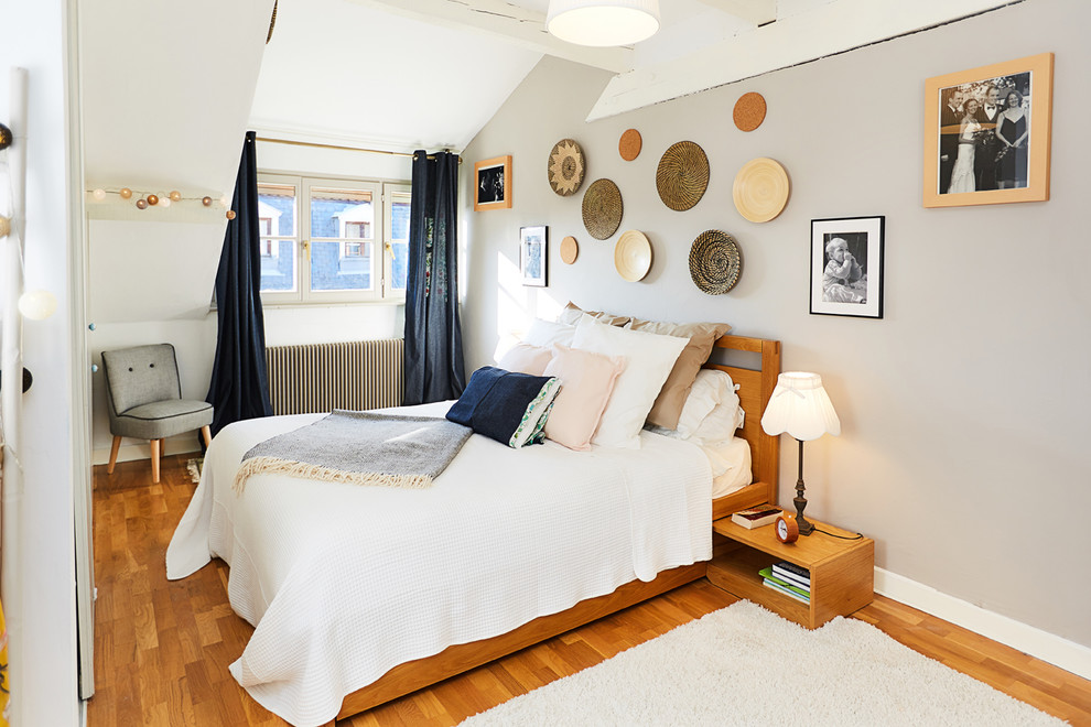 Idée de décoration pour une chambre parentale tradition de taille moyenne avec un sol marron, un mur blanc et parquet clair.