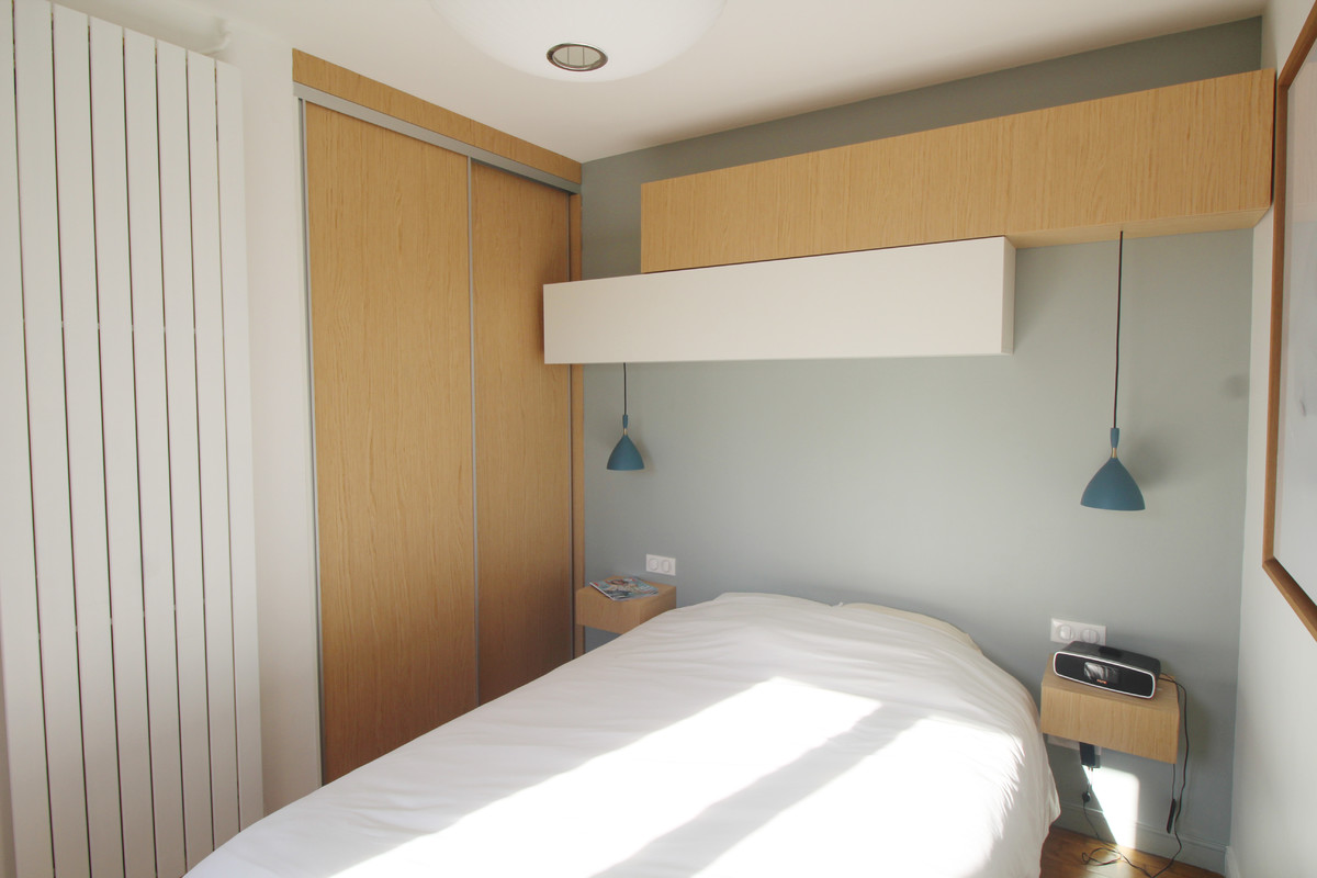 Ejemplo de dormitorio principal escandinavo pequeño con paredes grises y suelo de madera clara