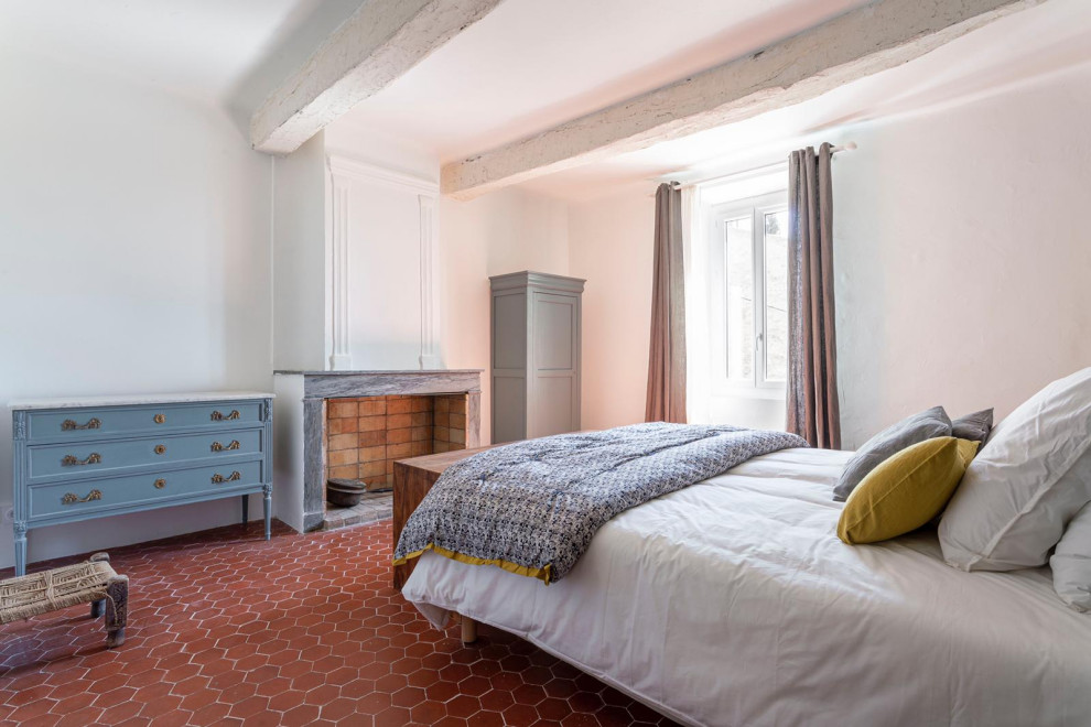 他の地域にある中くらいなエクレクティックスタイルのおしゃれな寝室 (テラコッタタイルの床、標準型暖炉、石材の暖炉まわり) のレイアウト