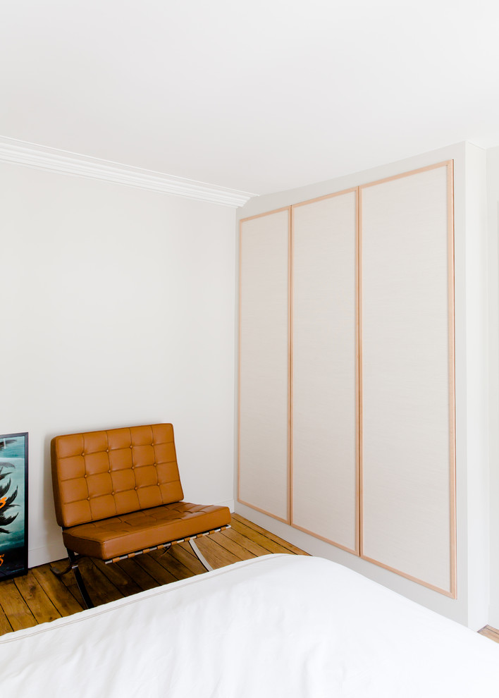 Cette photo montre une chambre parentale moderne de taille moyenne avec un mur blanc, parquet clair et un sol marron.