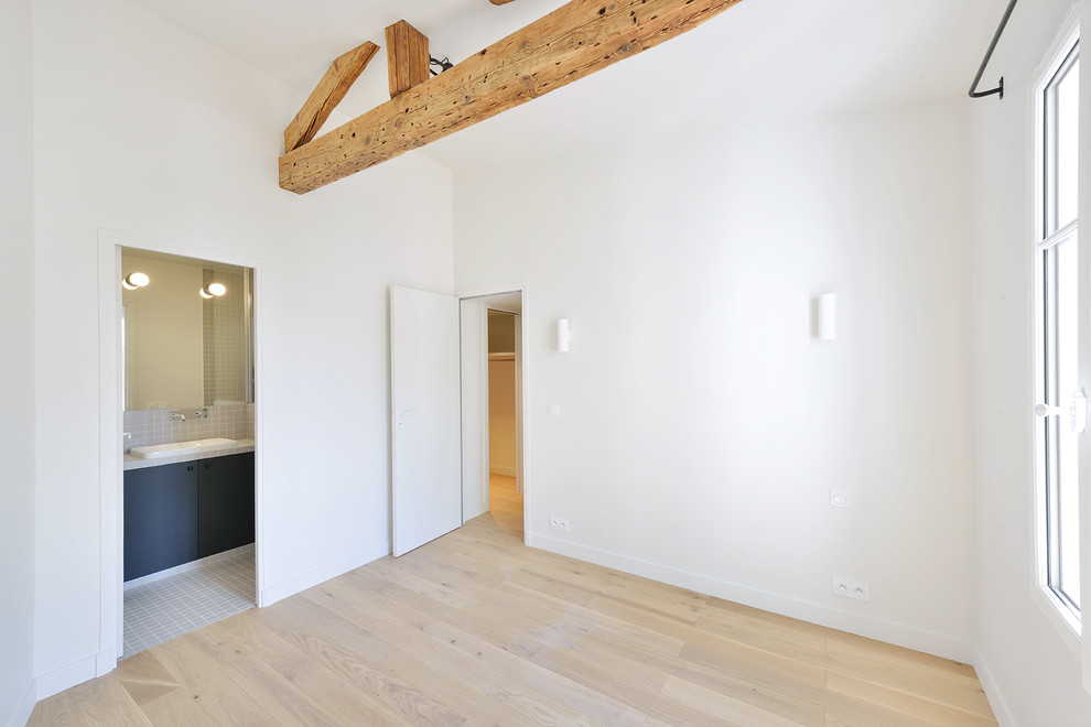 Ejemplo de dormitorio principal minimalista de tamaño medio sin chimenea con paredes blancas, suelo de cemento y suelo blanco