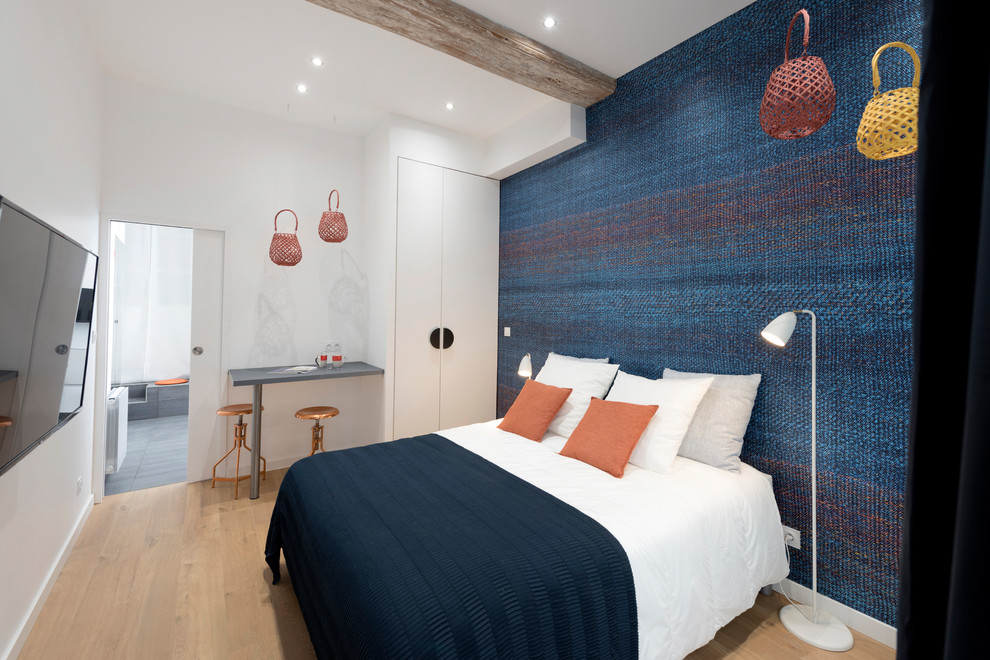 Diseño de dormitorio principal actual grande sin chimenea con paredes multicolor, suelo de madera clara y suelo beige