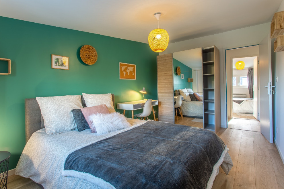 Immagine di una camera degli ospiti nordica di medie dimensioni con pareti verdi e parquet chiaro