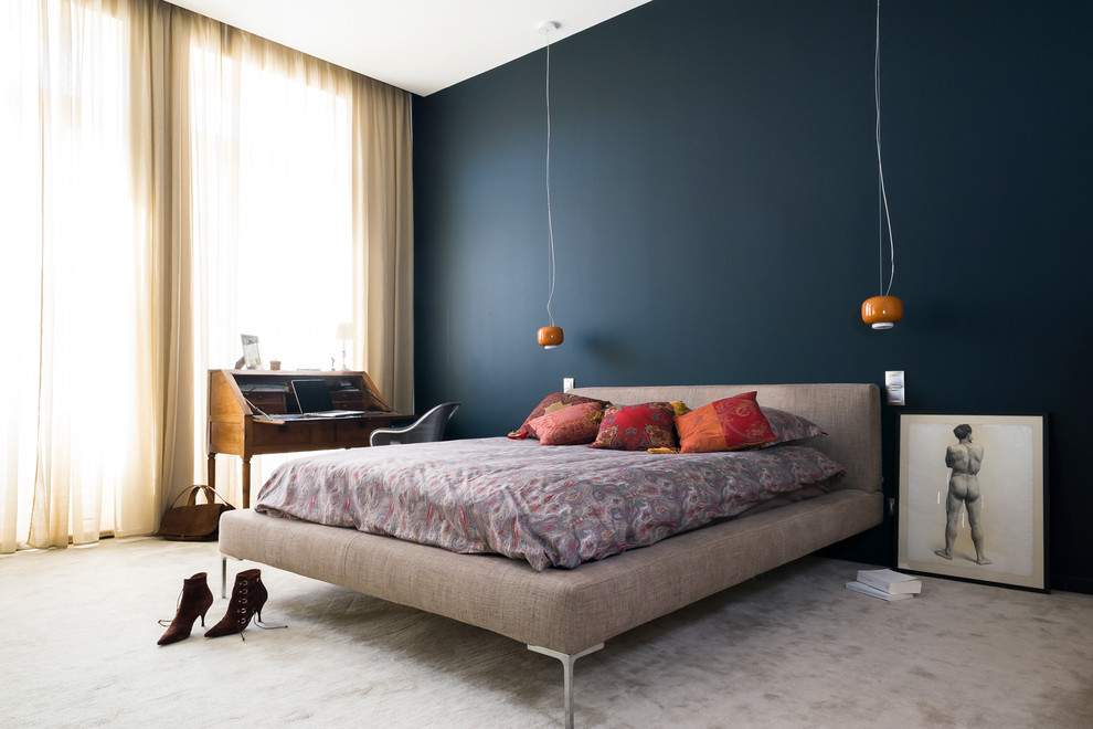 Idee per una grande camera matrimoniale minimal con pareti blu e moquette