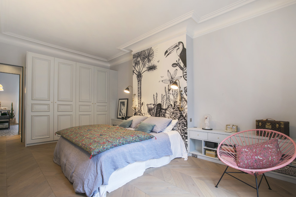 Eclectic grey and pink bedroom in Paris with grey walls, light hardwood flooring and beige floors.