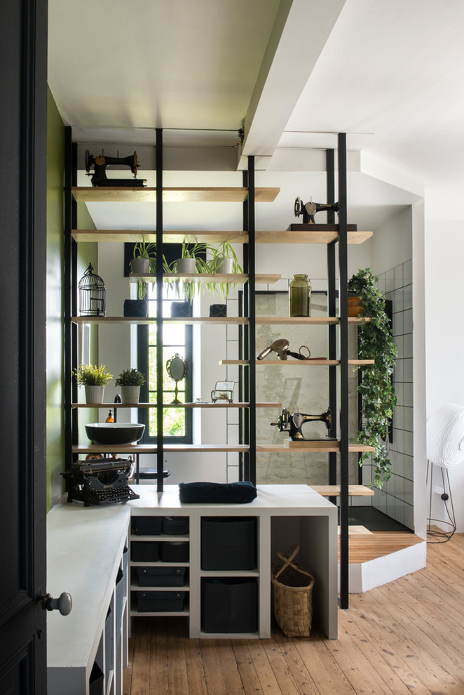 Imagen de habitación de invitados bohemia de tamaño medio sin chimenea con paredes verdes, suelo de madera clara y suelo beige