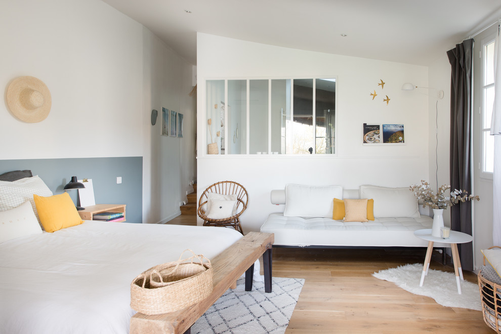 Cette photo montre une chambre parentale scandinave avec un mur blanc, parquet clair, aucune cheminée et un sol beige.