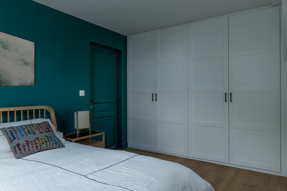 Großes Modernes Hauptschlafzimmer mit blauer Wandfarbe, hellem Holzboden und beigem Boden in Paris