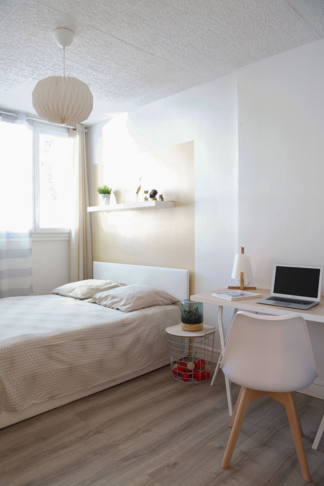 Minimalistisk inredning av ett litet gästrum, med laminatgolv, beiget golv och vita väggar