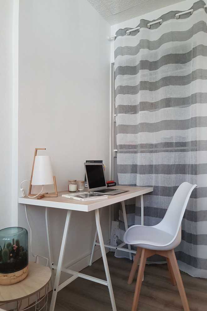 Imagen de habitación de invitados escandinava pequeña con paredes blancas, suelo laminado y suelo beige