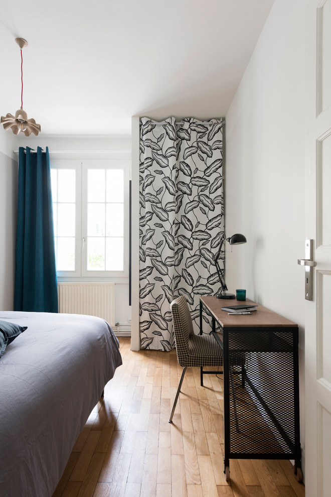 Ispirazione per una camera da letto design con pareti bianche, pavimento in legno massello medio e pavimento marrone