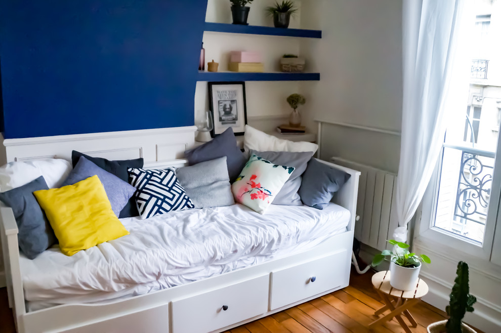 Diseño de dormitorio escandinavo de tamaño medio con paredes azules y suelo de madera clara