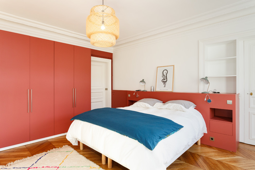 Пример оригинального дизайна: большая хозяйская спальня в стиле модернизм с красными стенами, паркетным полом среднего тона и коричневым полом без камина
