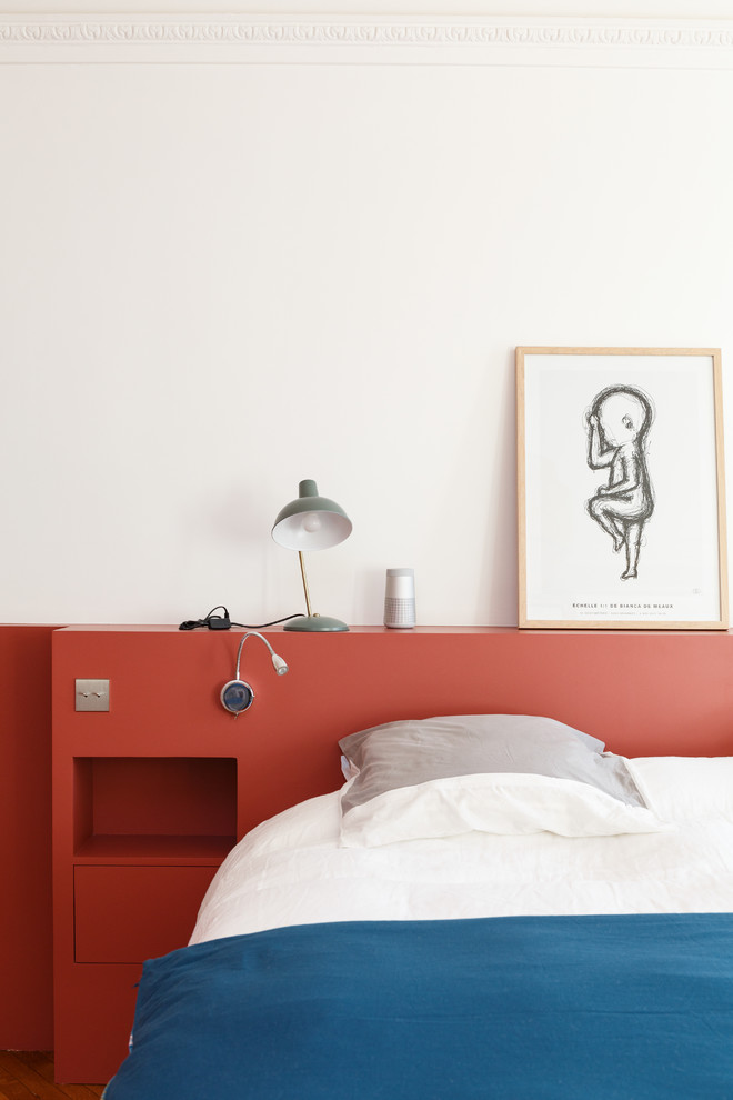 Modelo de dormitorio principal minimalista grande sin chimenea con paredes rojas, suelo de madera en tonos medios y suelo marrón