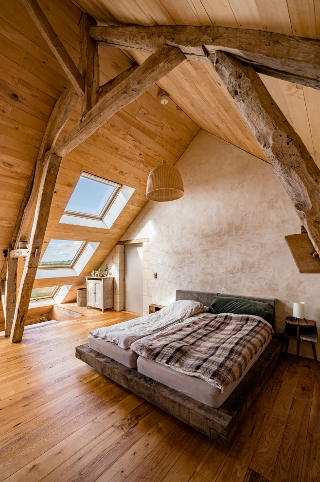 Cette image montre une chambre parentale rustique de taille moyenne avec un mur beige, un sol en bois brun, aucune cheminée, un sol beige et un plafond en bois.