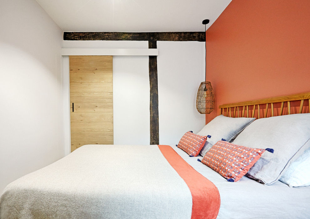 Foto på ett mellanstort eklektiskt gästrum, med röda väggar, ljust trägolv och beiget golv