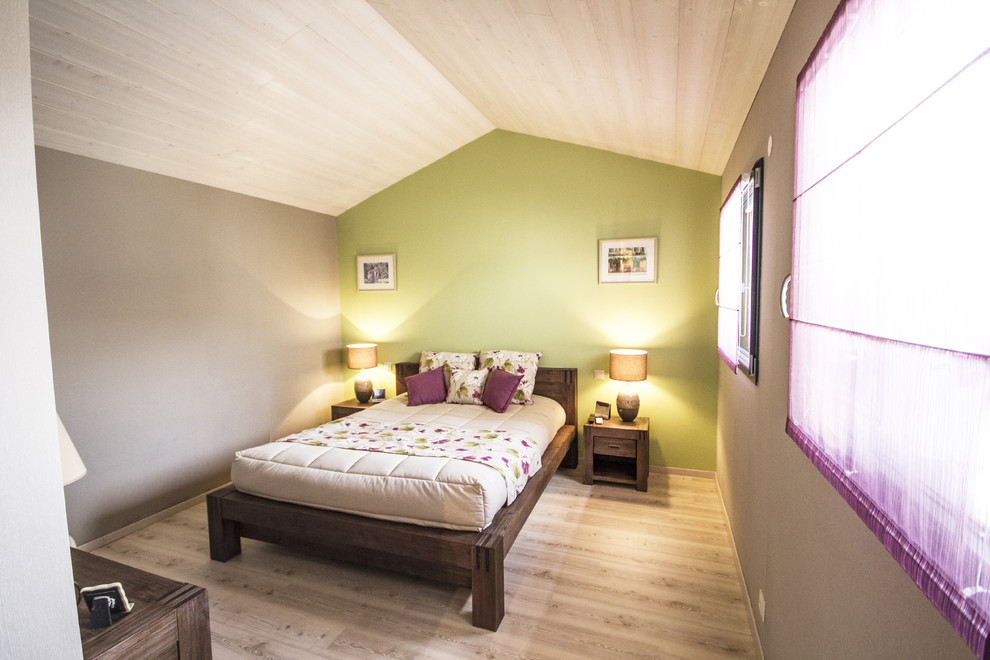 Lantlig inredning av ett sovrum, med gröna väggar och ljust trägolv