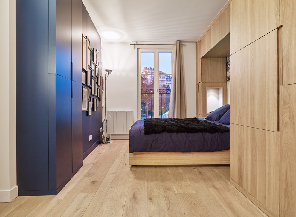 パリにある中くらいなコンテンポラリースタイルのおしゃれな主寝室 (青い壁、淡色無垢フローリング、暖炉なし) のインテリア