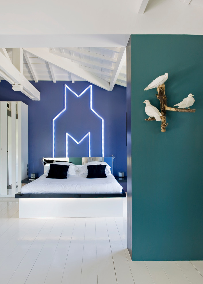 На фото: большая спальня в современном стиле с деревянным полом и синими стенами