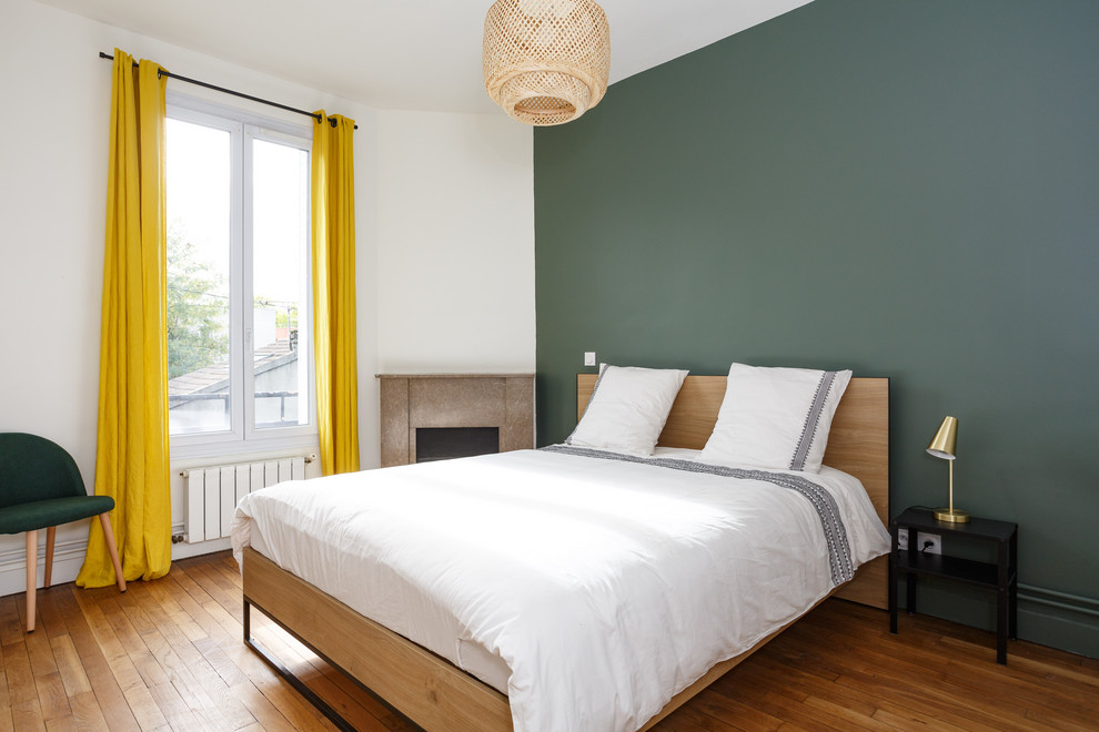 Modernes Schlafzimmer mit grüner Wandfarbe, braunem Holzboden und braunem Boden in Paris